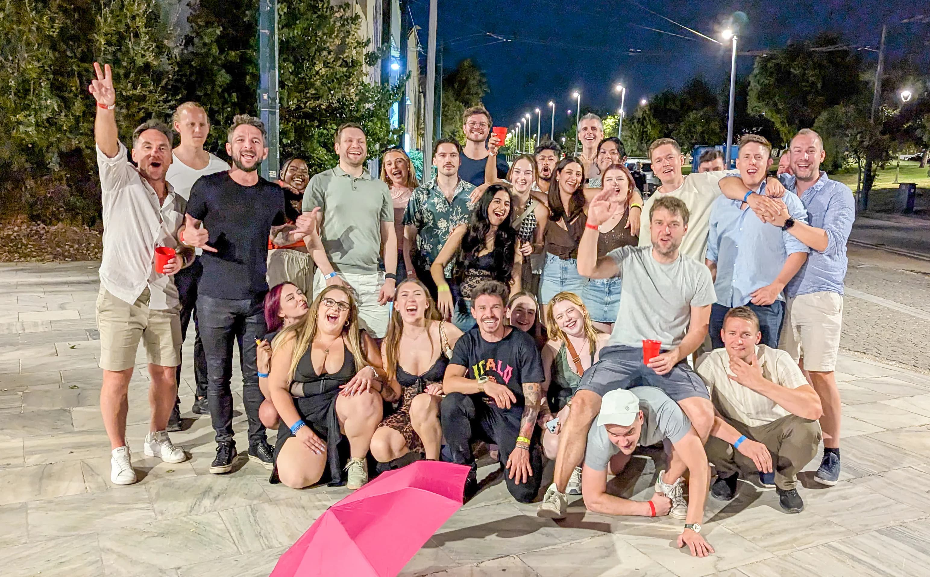 Vibrant group celebration during Athens pub crawl featuring meet travelers athens nightlife tour in Athens district